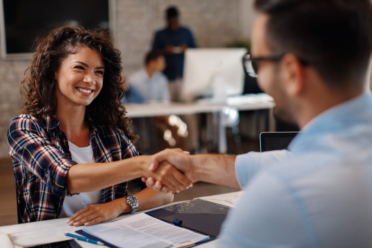 Woman and man shaking hands at an office desk