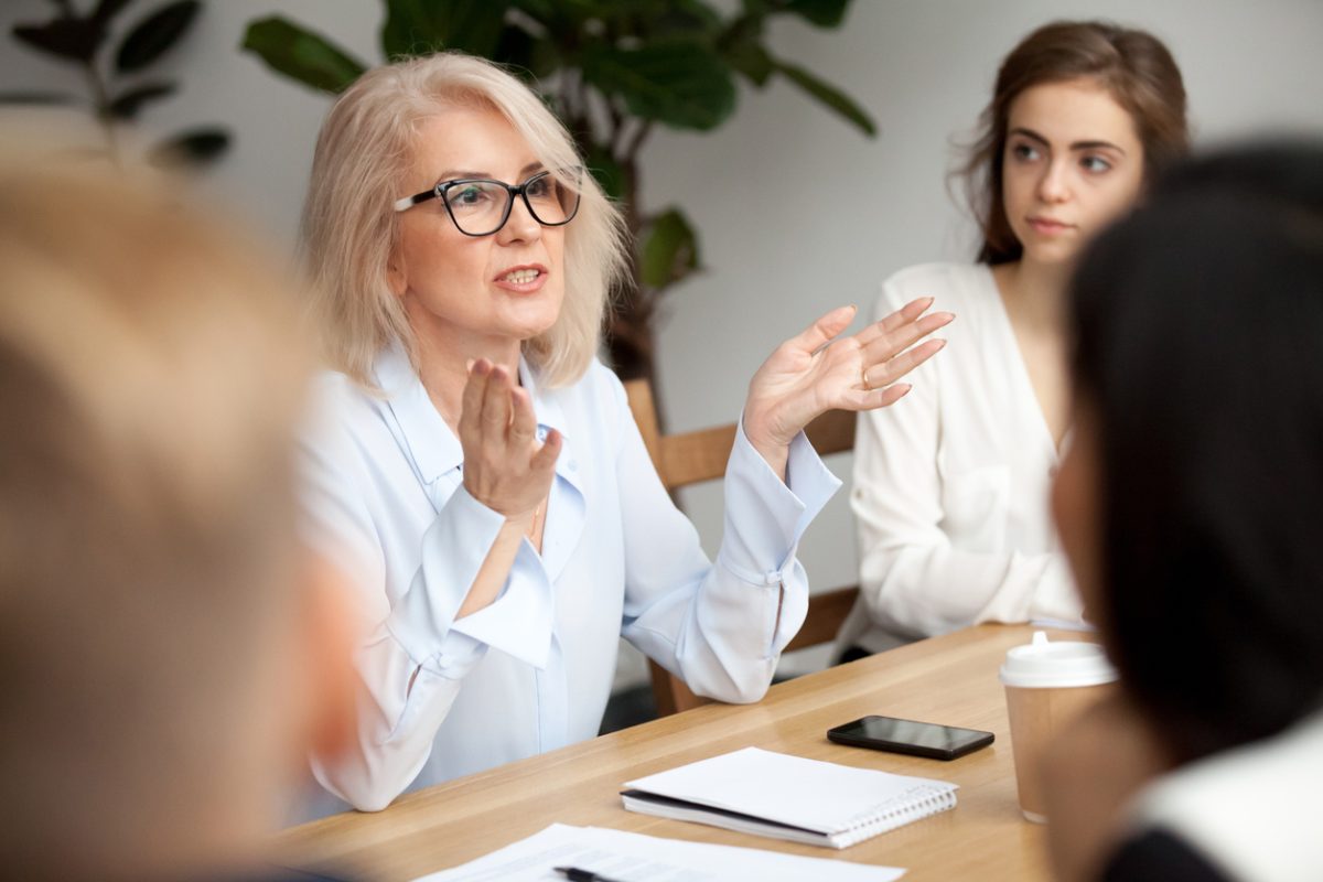 Business woman talking to group of workers