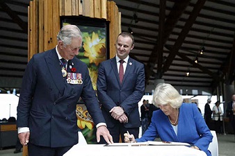 woman signing book, standing men