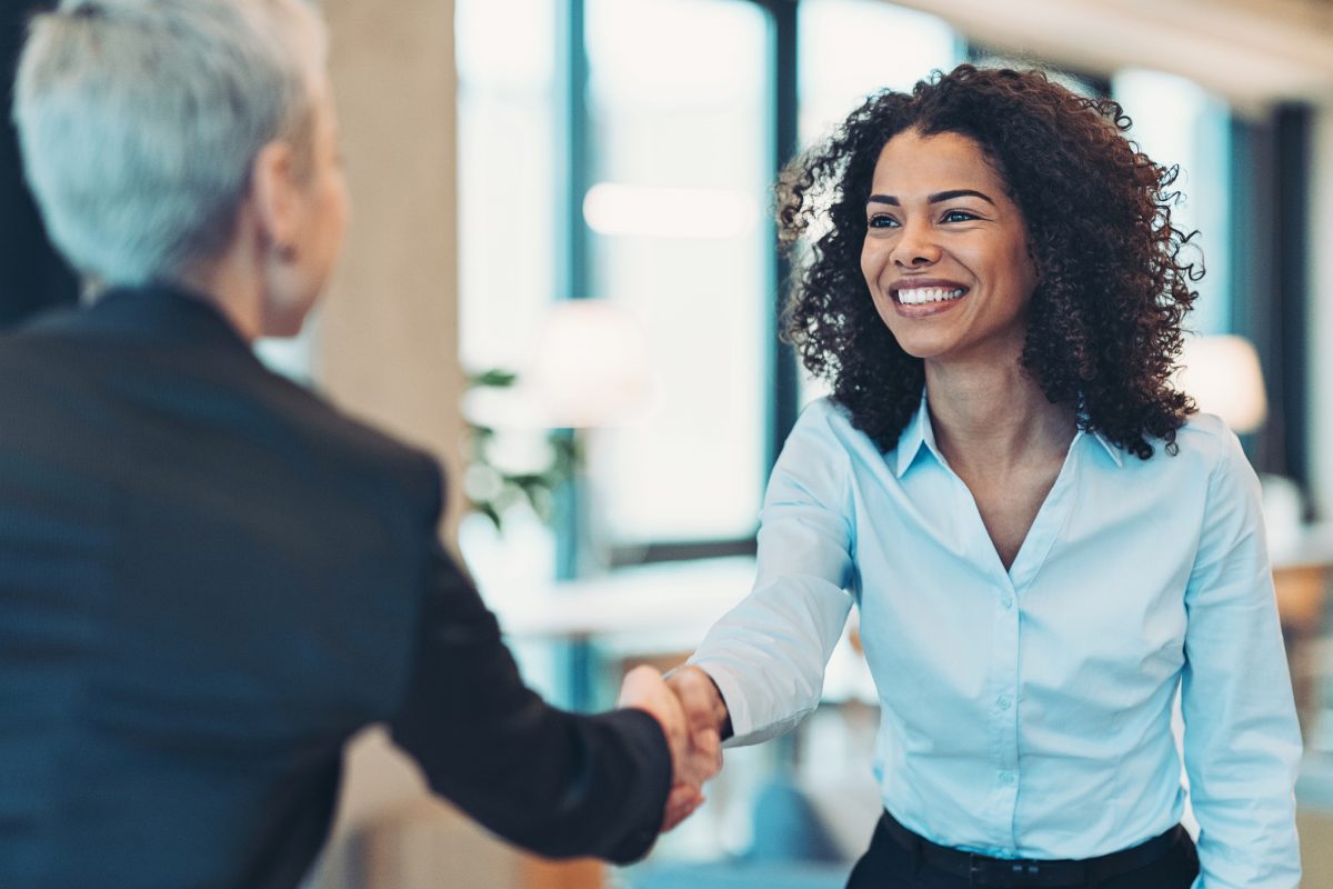 two women shaking hands in an office