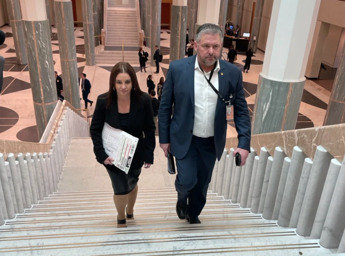 Jacquie Lambie and man walking up steps in Parliament House