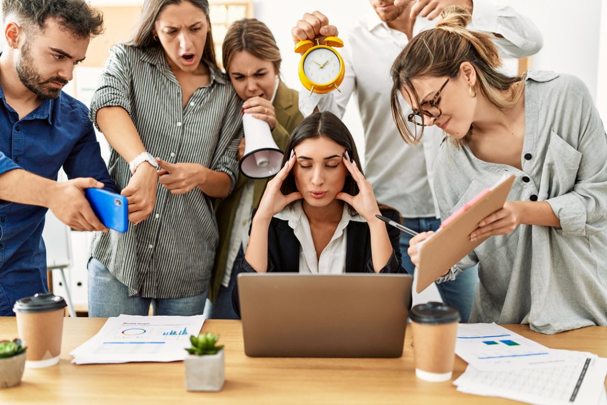 office workers crowding a woman at a computer