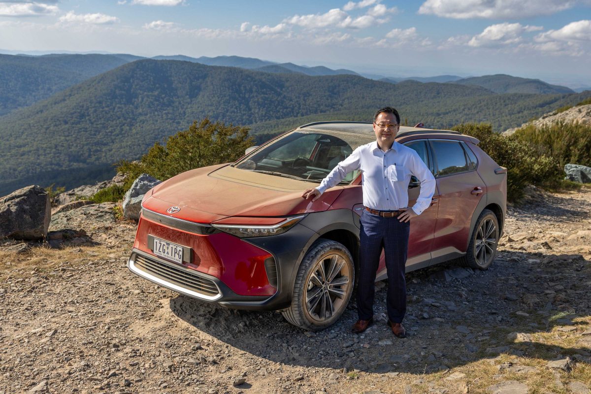 man standing next to a car on a mountain