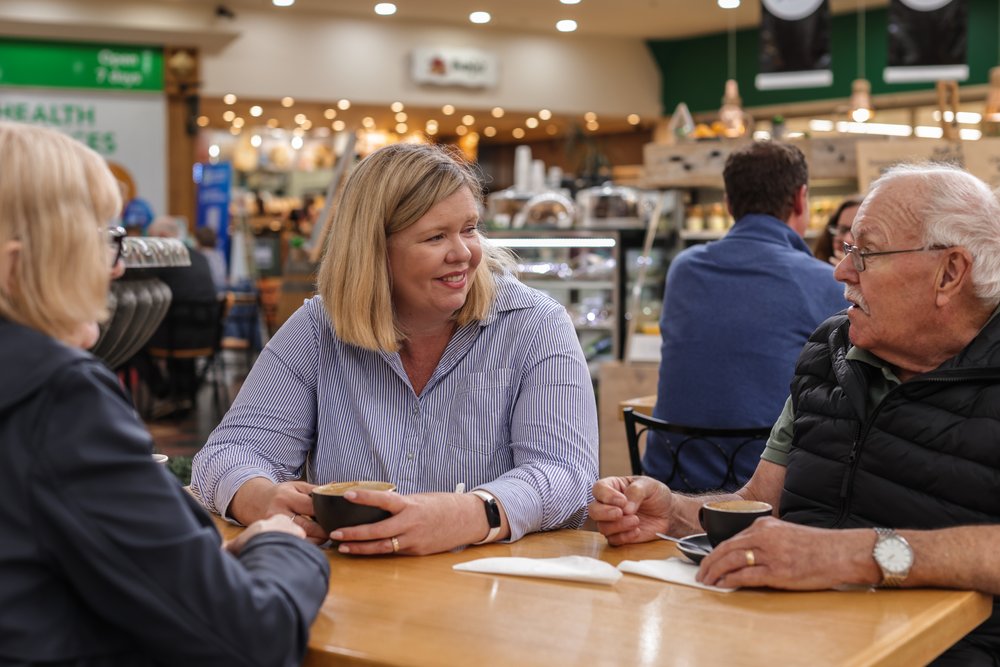 woman witting with two older people in a cafe