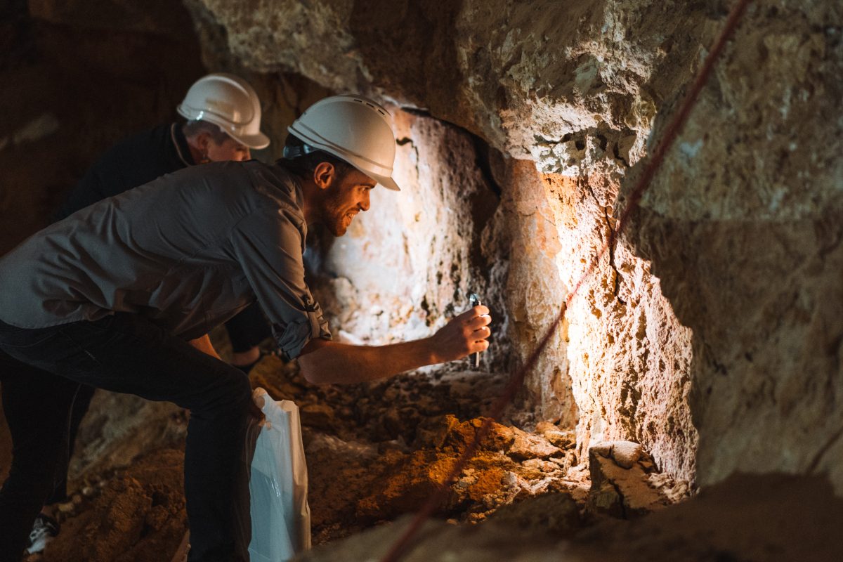 Men in hard hats in rock cave