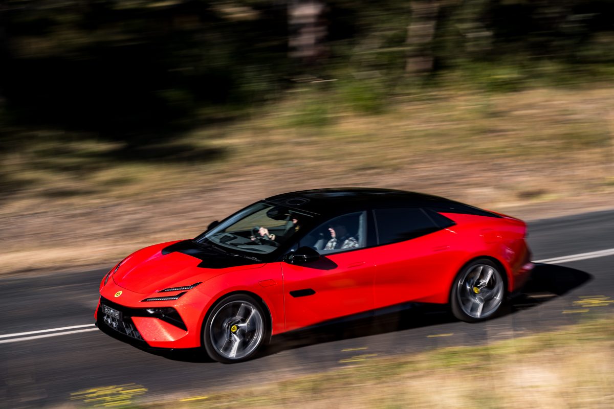 Red sports car driving along a road fast