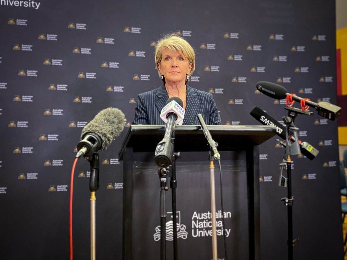 Julie Bishop standing at a lectern with microphones