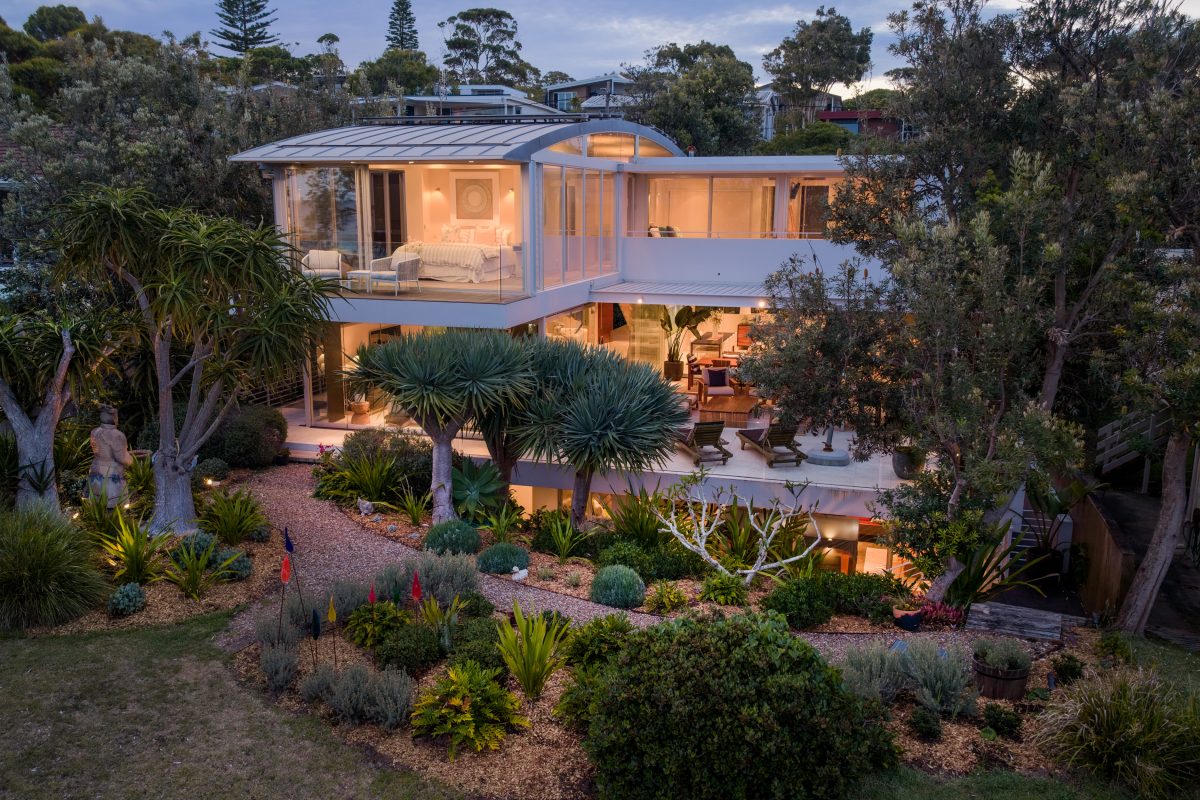 modern tri-level house surrounded by lush landscaping