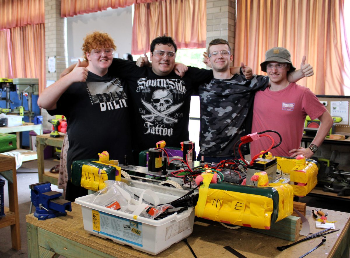 Four male students with robot.