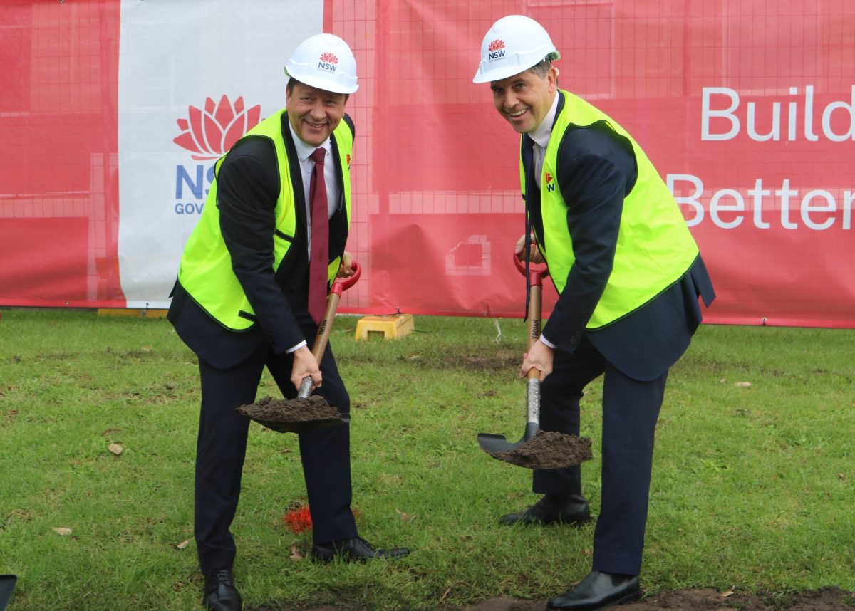 Two men with shovels of soil at a construction site