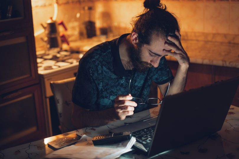 stressed-looking man at his computer at home