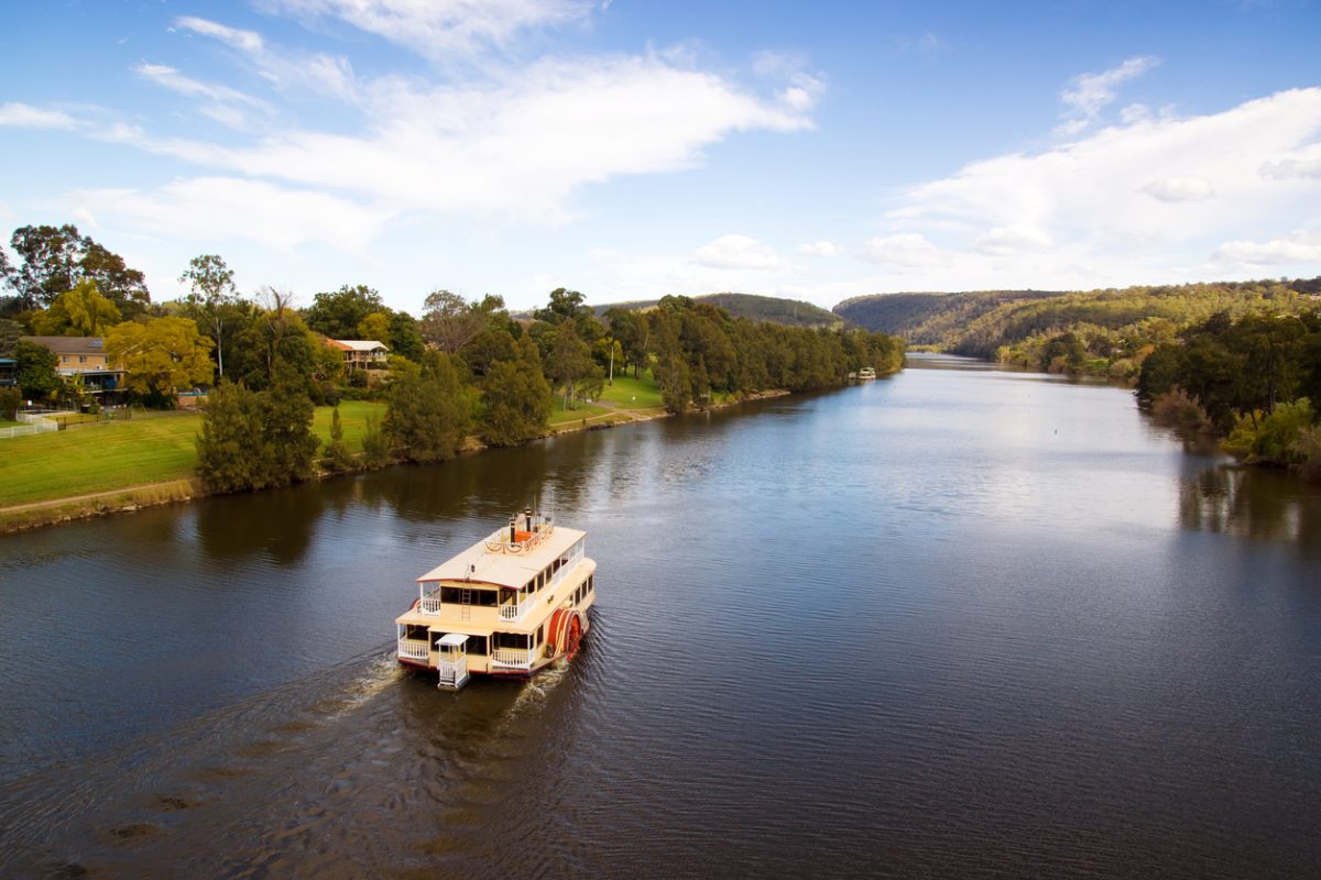 A classic paddlewheeler makes its way down the Nepean River, passing houses in Penrith along the way. 
