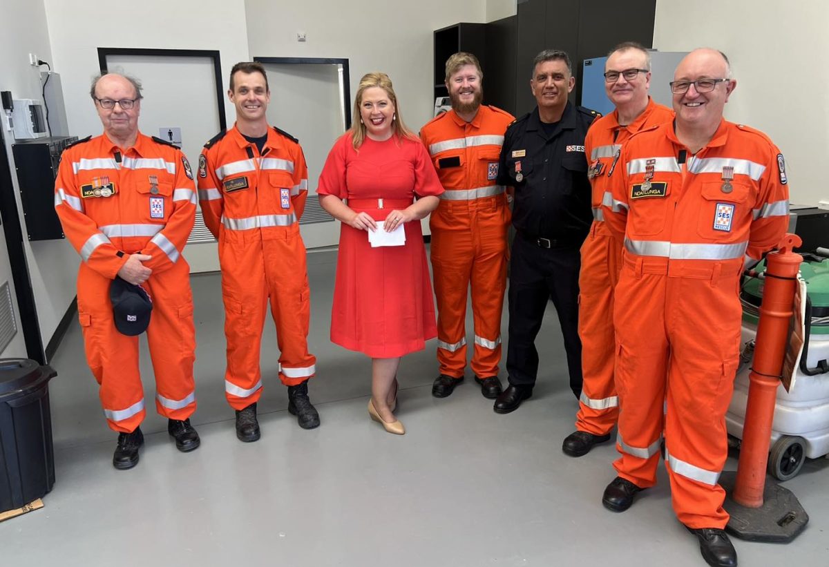 SES volunteers in orange and a female politician