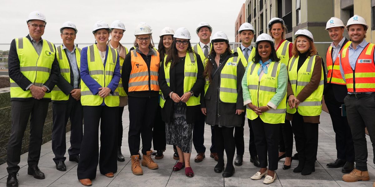 The ministers standing alongside each other and the project workers in high-vis gear at the Prahran worksite.
