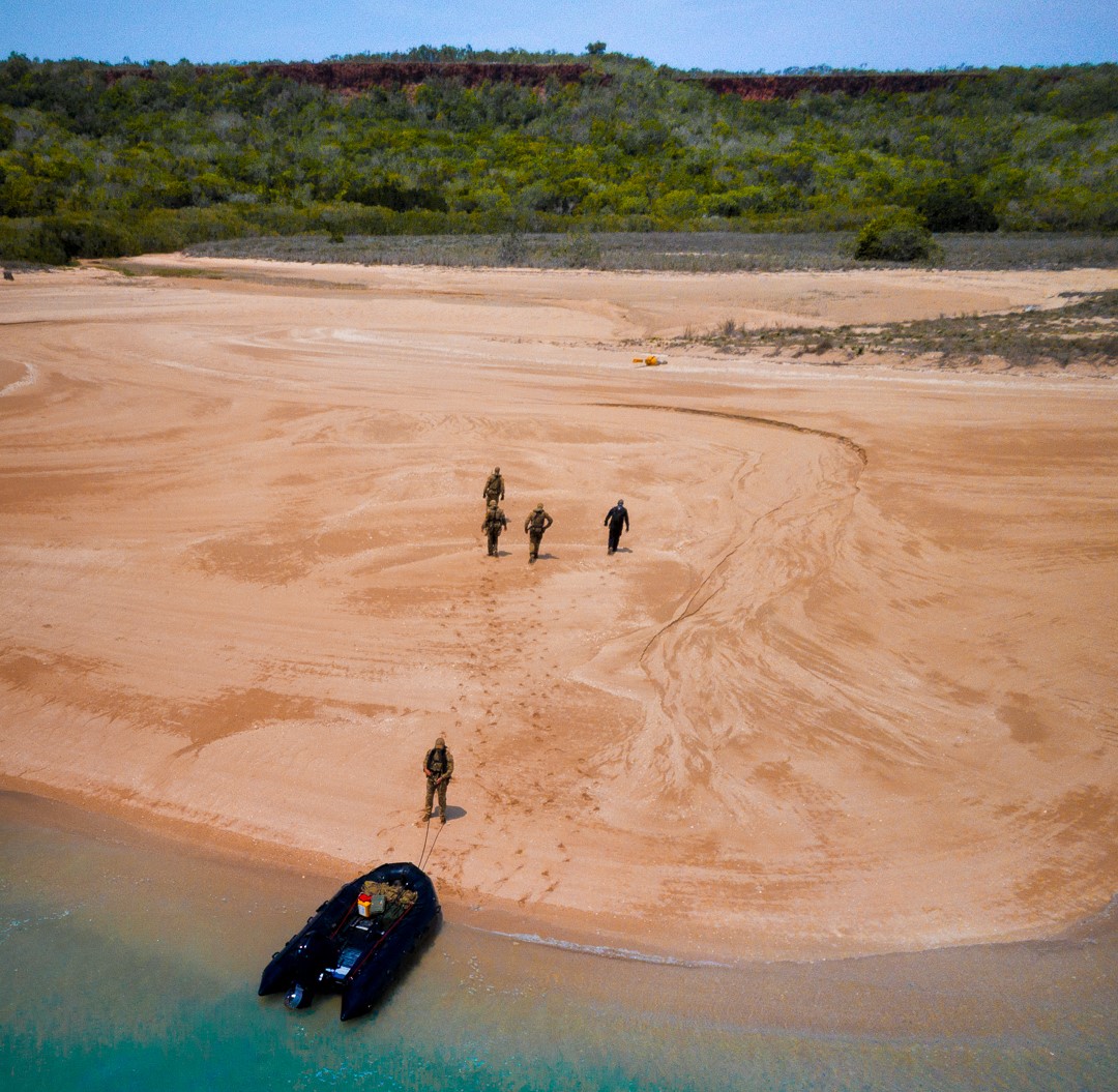 Soldiers and an ABF officer survey a beach for illegal fishing activities in a WA marine park