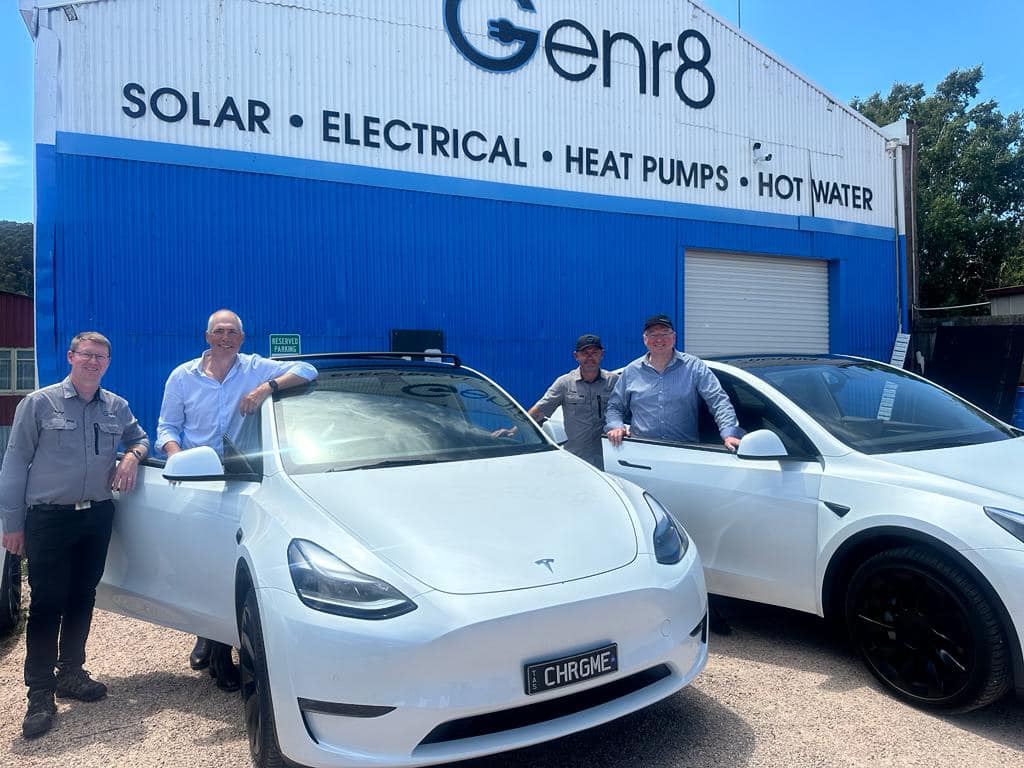 Roger, Nathan and Nick standing around Teslas in front of the Genr8 warehouse.