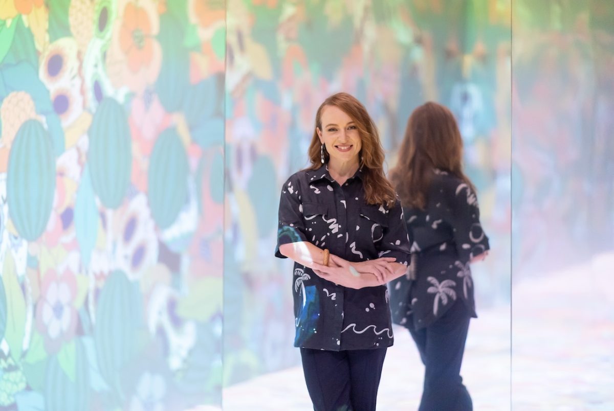 woman standing in front of colourful artwork