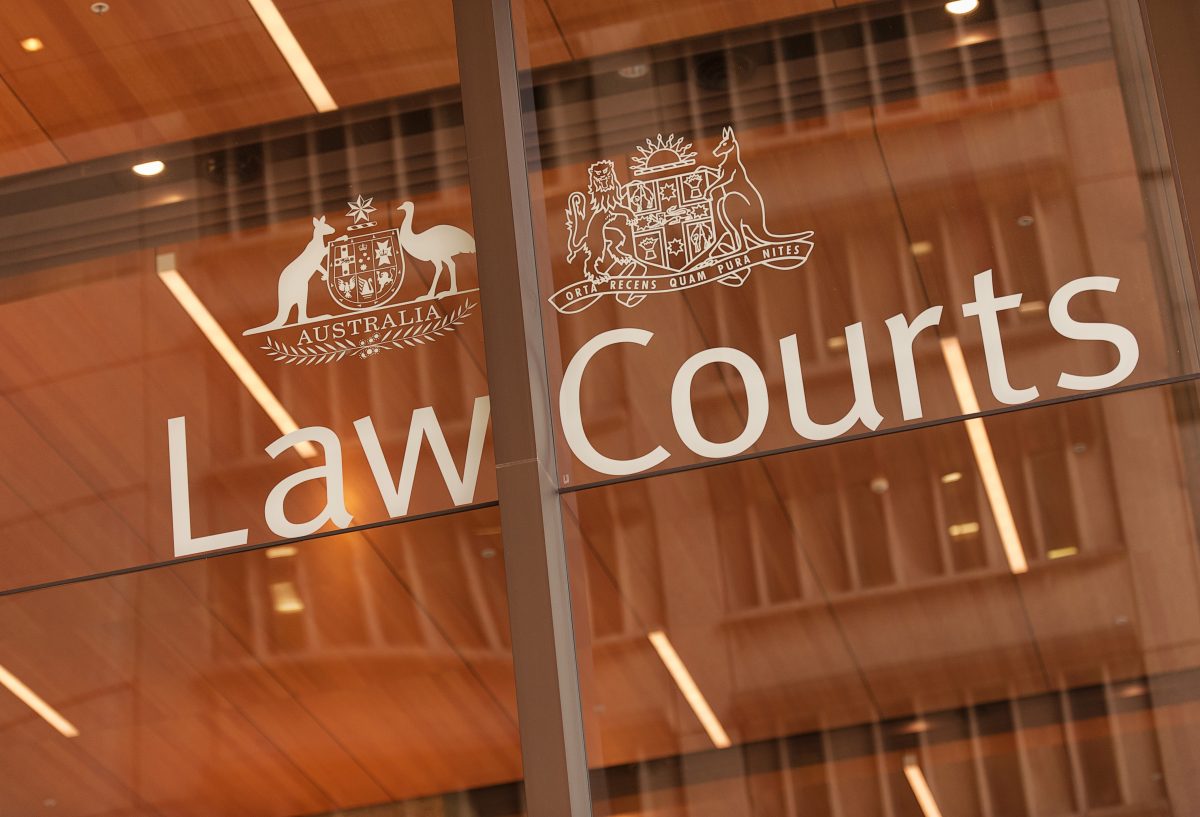 Glass signage reading ''Law Courts'' with the nation's coat of arms above