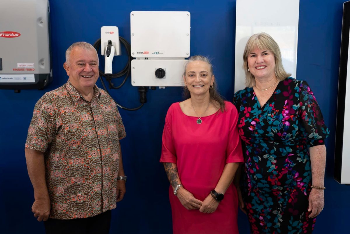 Ms Worden and Lawler standing beside a Darwin solar battery business owner and one of their products.