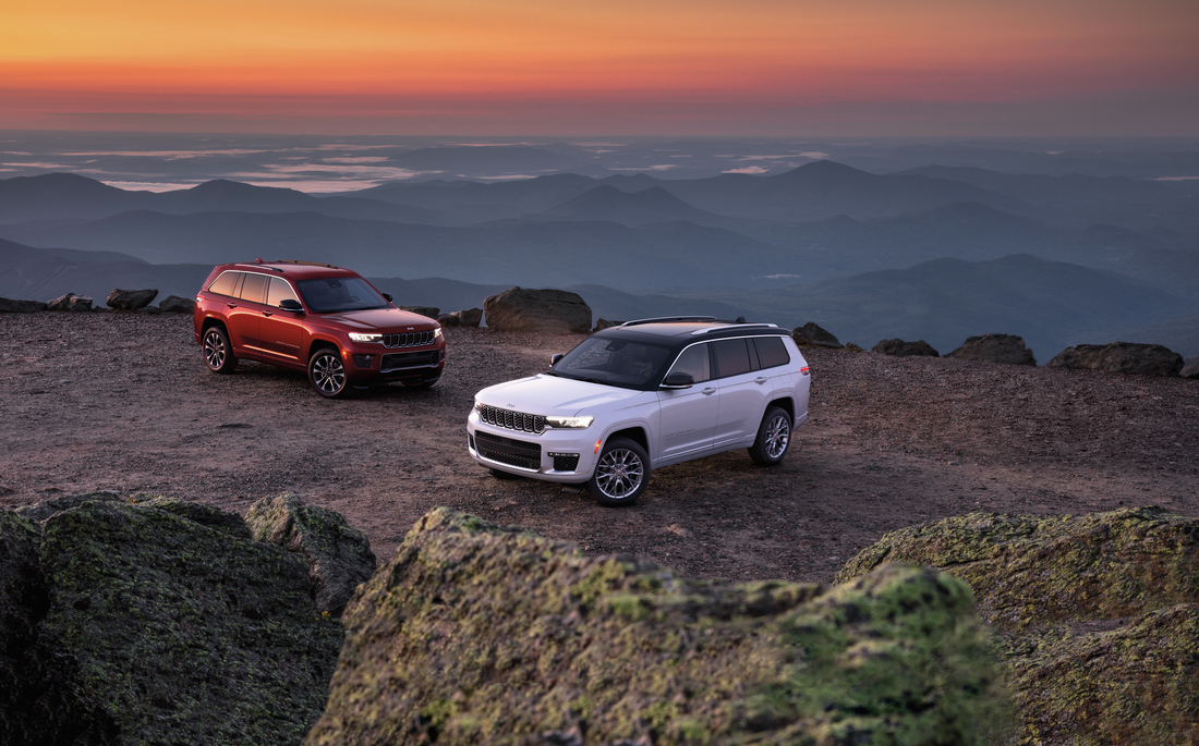 two luxury SUVs atop a mountain
