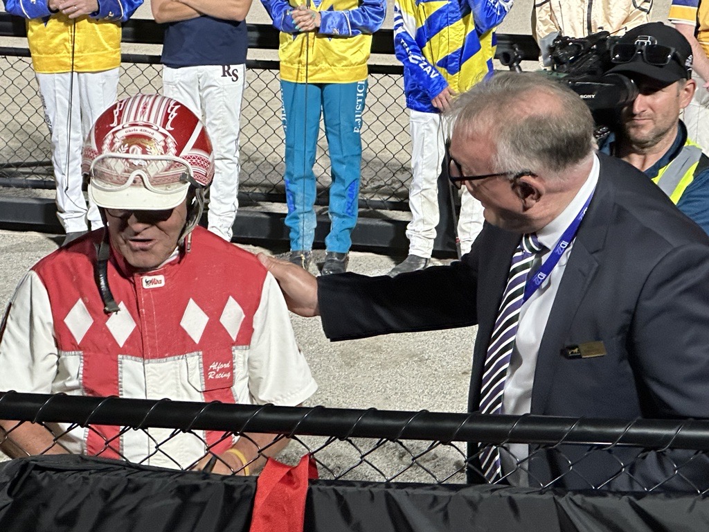 Dale Monteith patting the back of a harness racing jockey