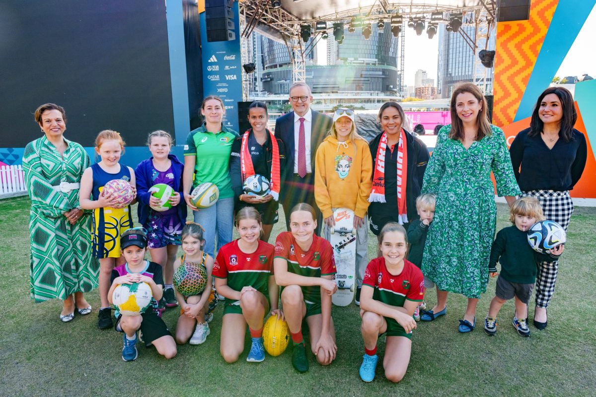 The PM with Anika Wells, Michelle Rowland and a group of children in front of a concert stage.