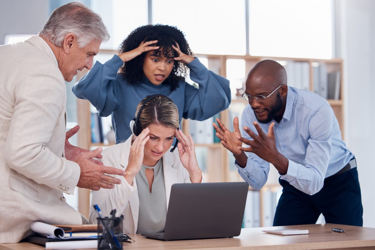 four animated people looking at a laptop in an office