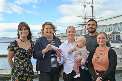Community representatives with Hobart's Lord Mayor on a pier with an old ship and the water behind them.