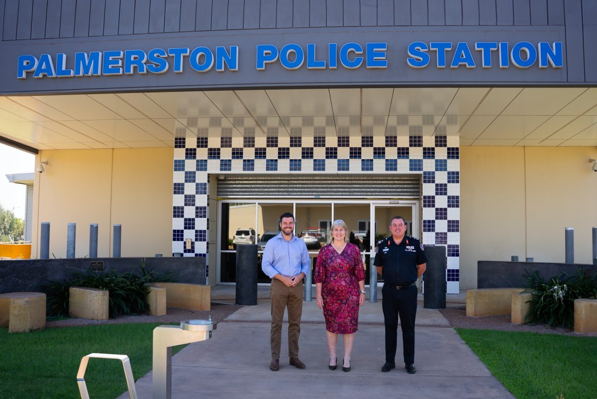 a police officer and two politicians outside a police station