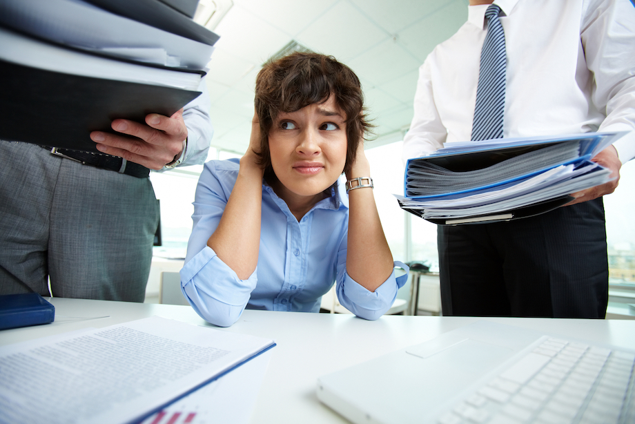 woman stressing as people give her more files