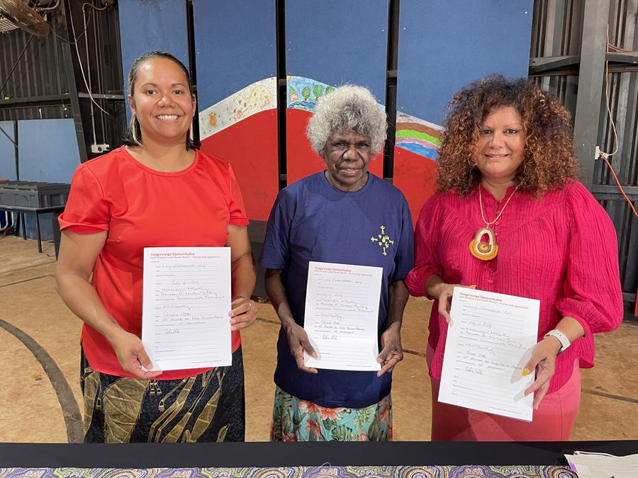 three women holding documents