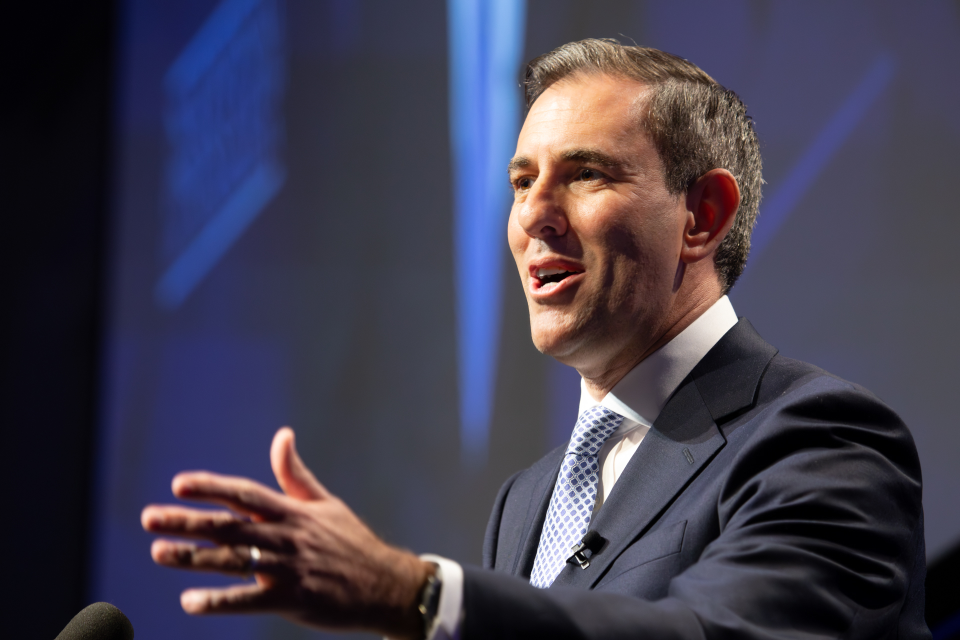 man in a suit on stage giving an address