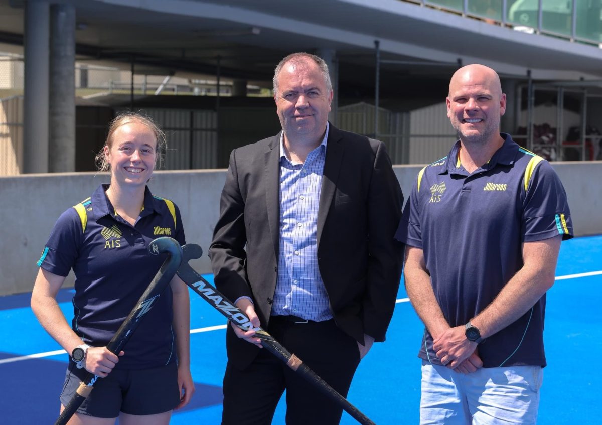 two men and a female hockey player