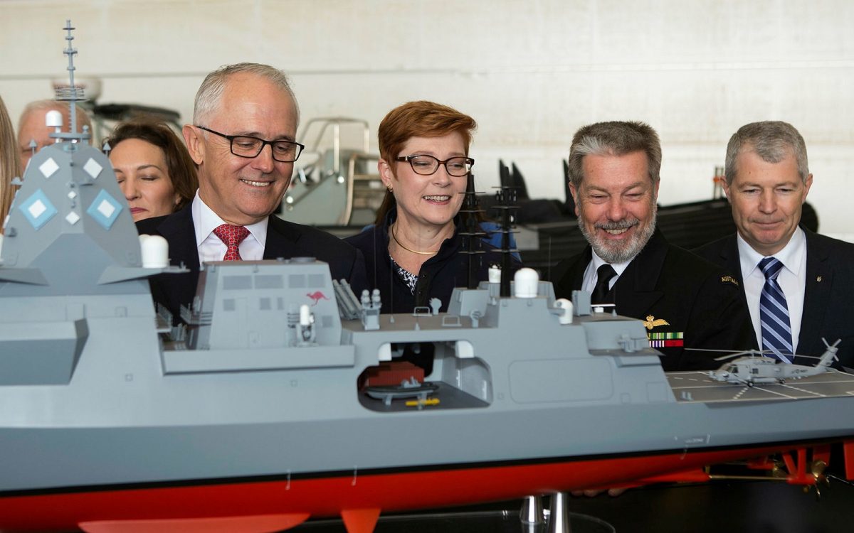 officials looking at a model submarine