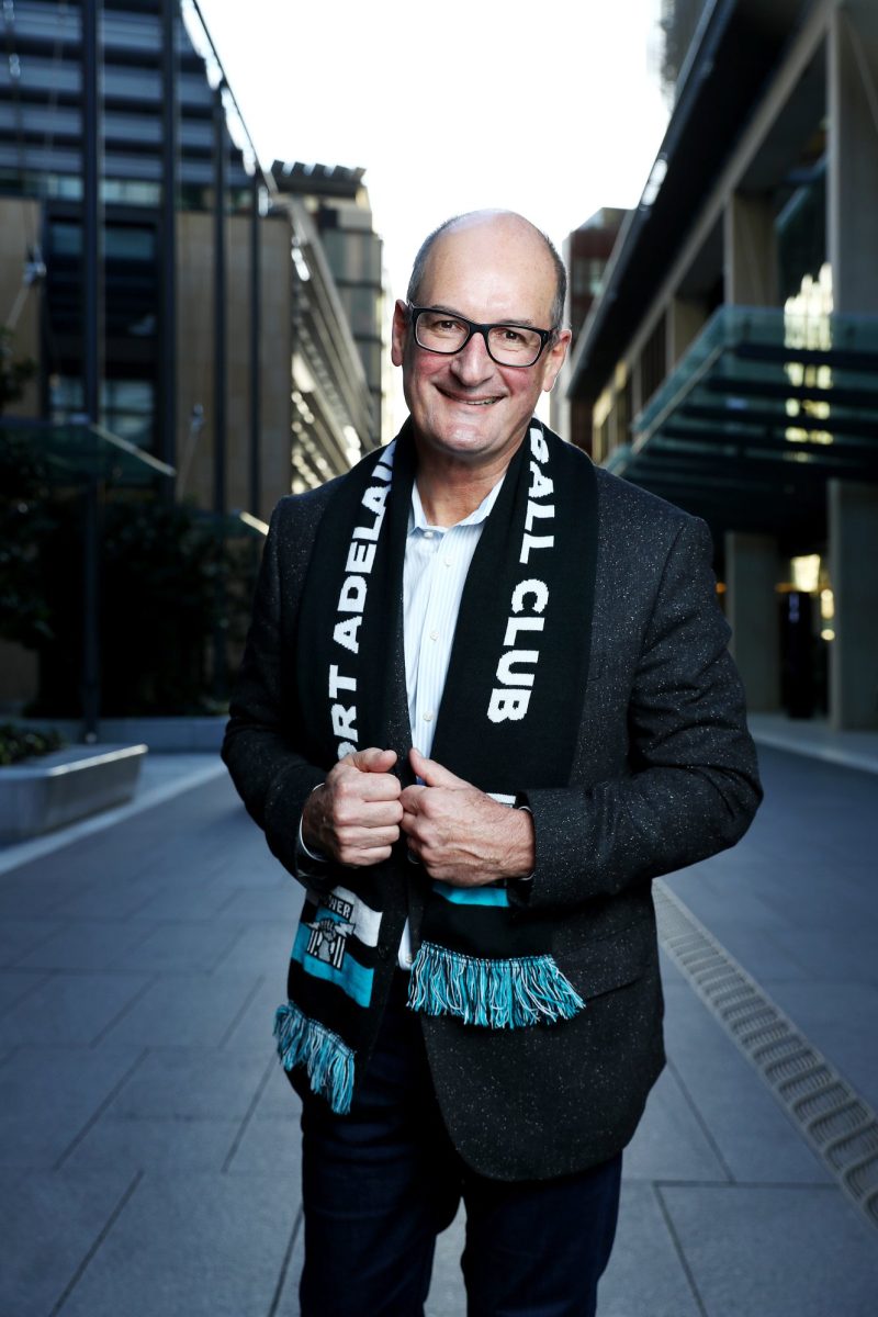 smiling man wearing football scarf