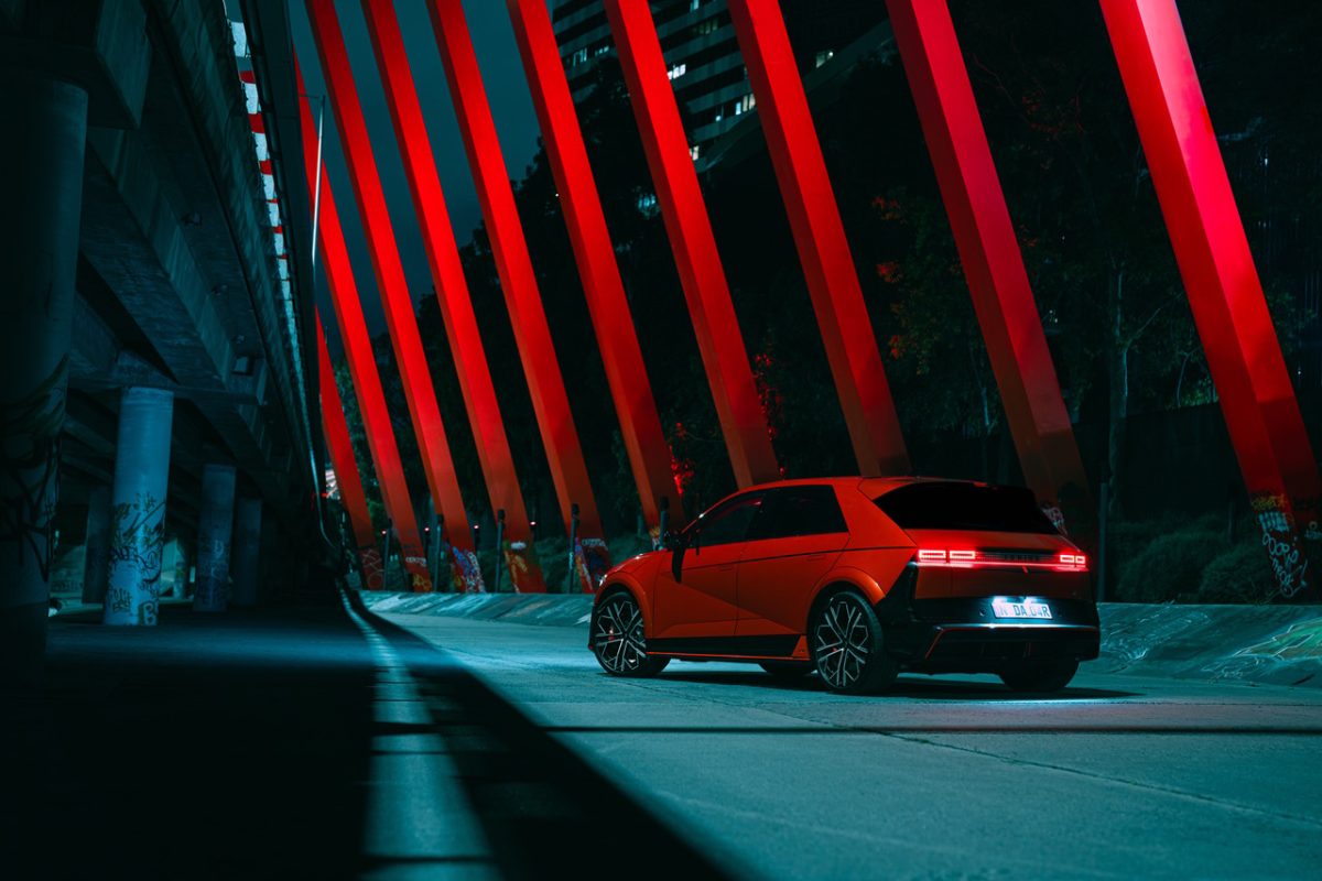 shiny new red car under red pillars