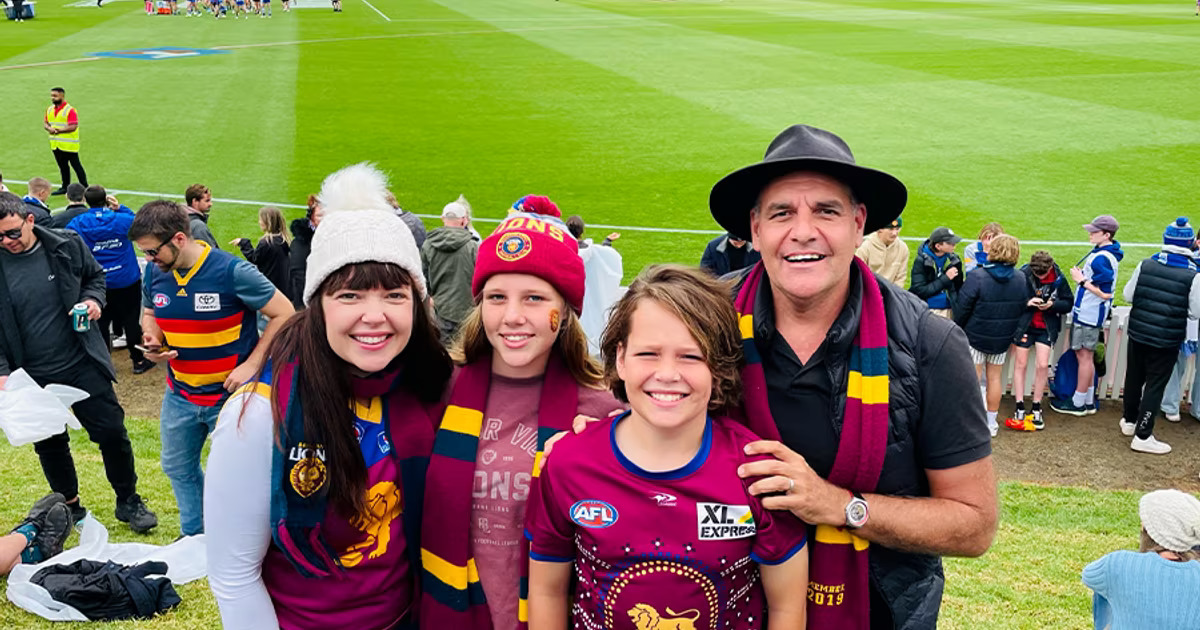 man and kids at AFL match