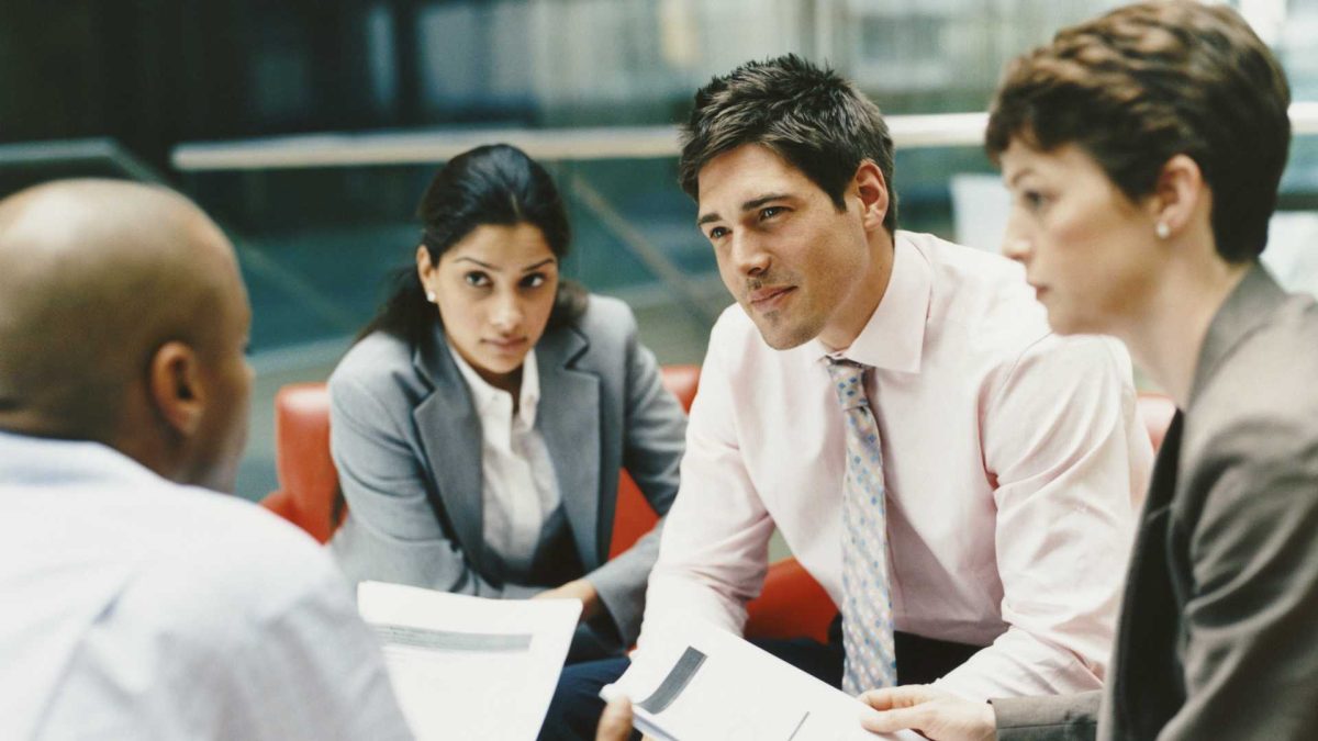 four people in an office meeting