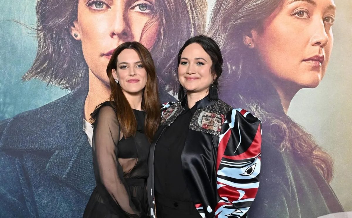 two actors in front of a movie poster of them