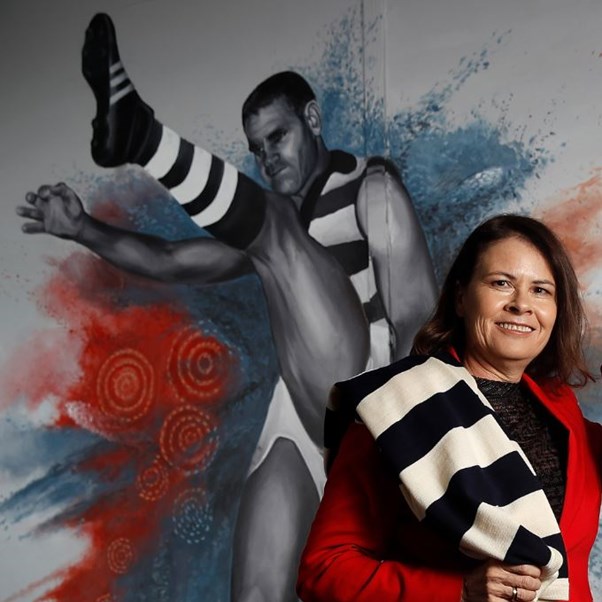 woman standing in front of a mural