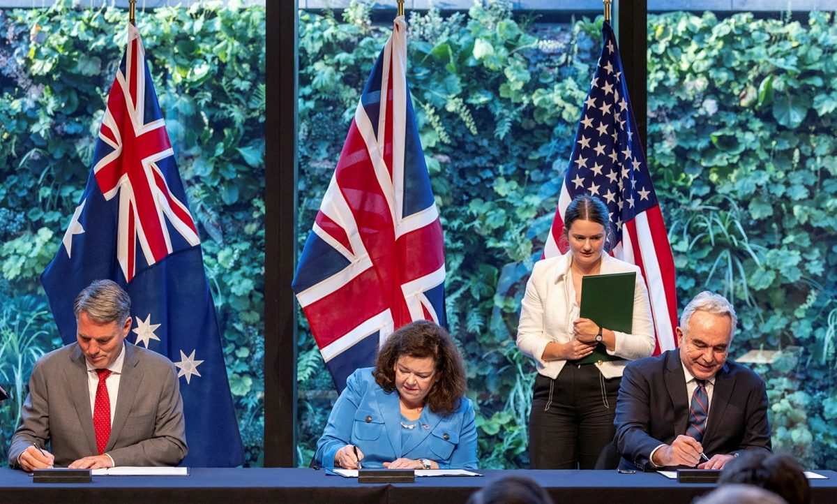 three governments' officials signing an agreement