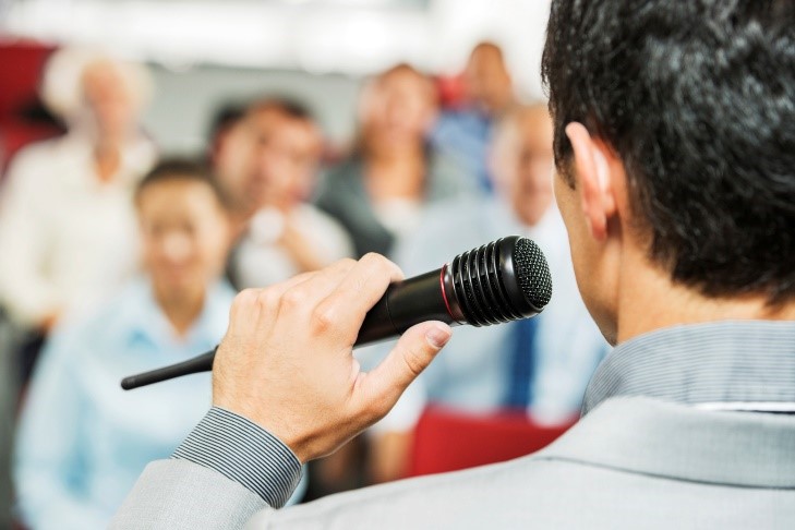 Man with microphone in front of crowd