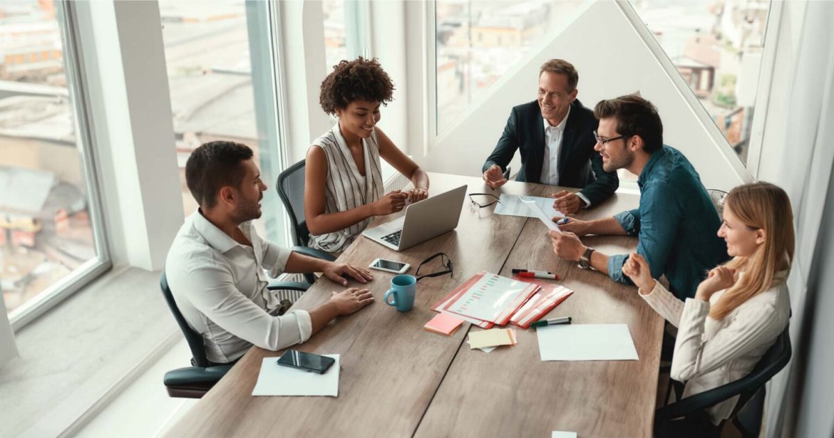 Five people sitting around an office table