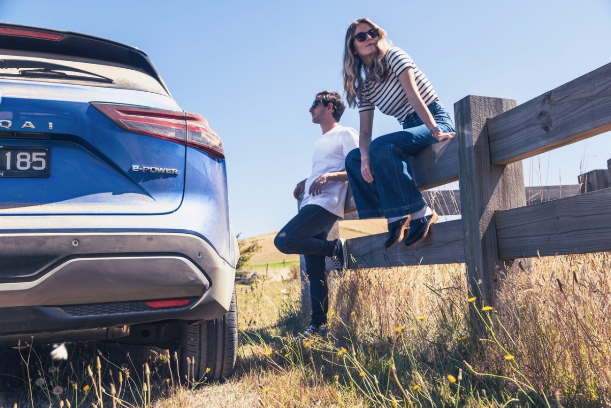 a man and a woman with a Nissan Qashqai in a rural field