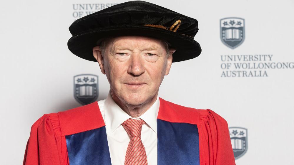 man wearing a university robe and cap