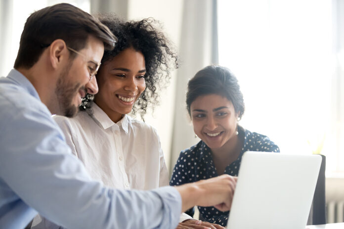 three people looking at a device