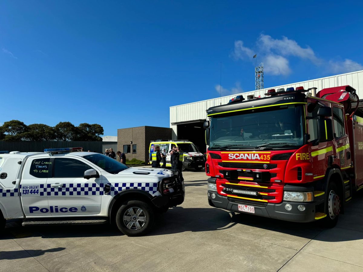 A police car, fire truck and ambulance stopped on a driveway. 