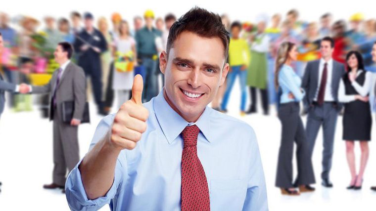 smiling man in office attire making a thumbs-up gesture