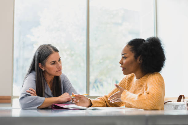 two women sitting at a table in an office