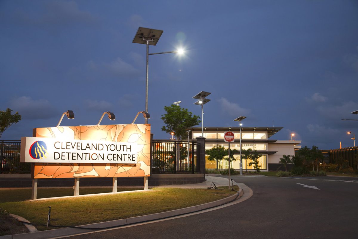 The front entrance of Cleveland Youth Detention Centre with a sign and front gates in view.